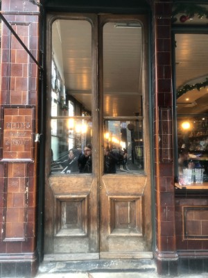 Glass panelled brown wooden doors. Push from middle to open.
