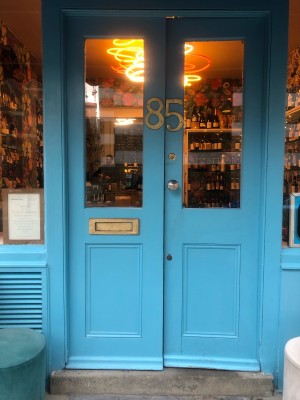 Glass panelled blue doors. Push from middle to open.