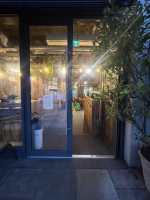 Glass doors with black frame and metal handles. Push from centre to open.