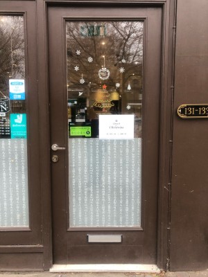 Glass panelled brown door. Push metal handle on left to open.