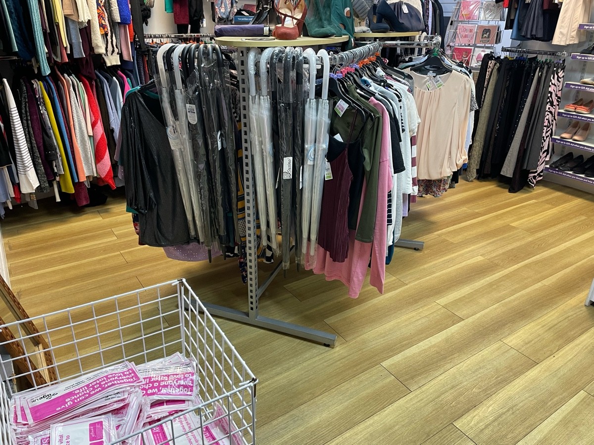 This photo is a view to the left of the entrance. There is a small basket to the left of the door and 2 clothing rails in the centre of the room.
