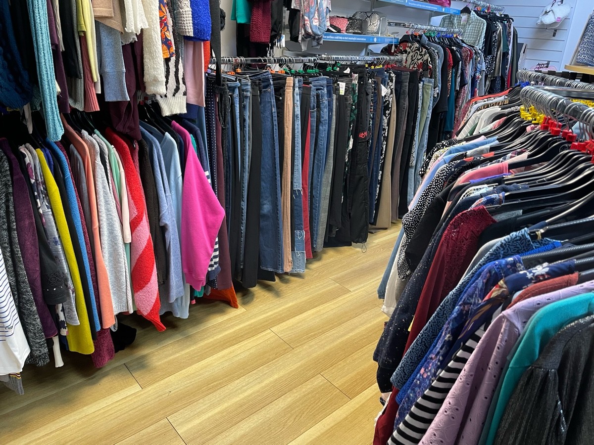 This photo is the path to the left of the clothing rails in the centre, with a clothing gondola to your right and rails along the walls to your left