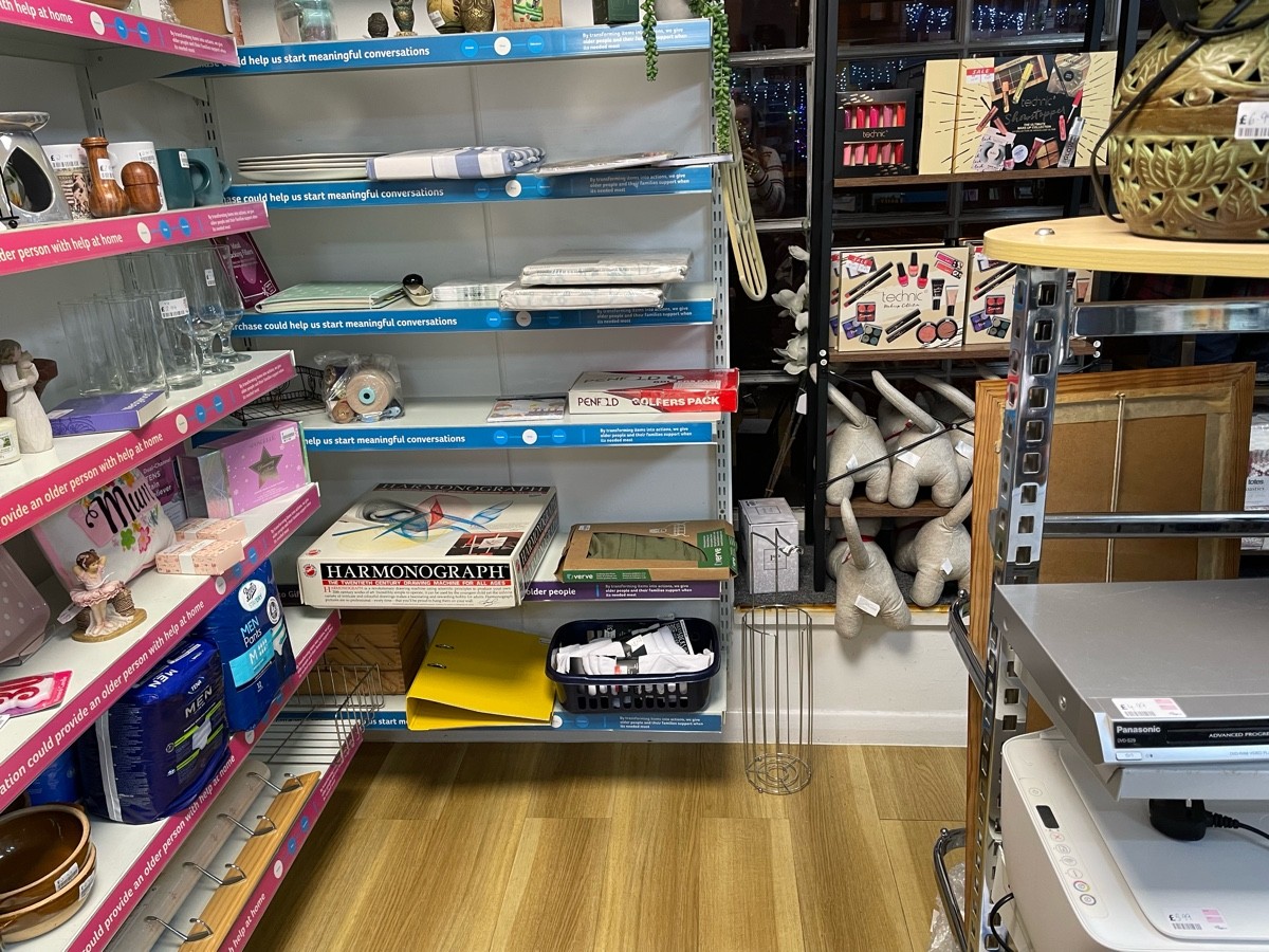 This photo is along the back wall of the side room, to your right are 2 racks, and the path to the door, to your left is shelving of bric-a-brac