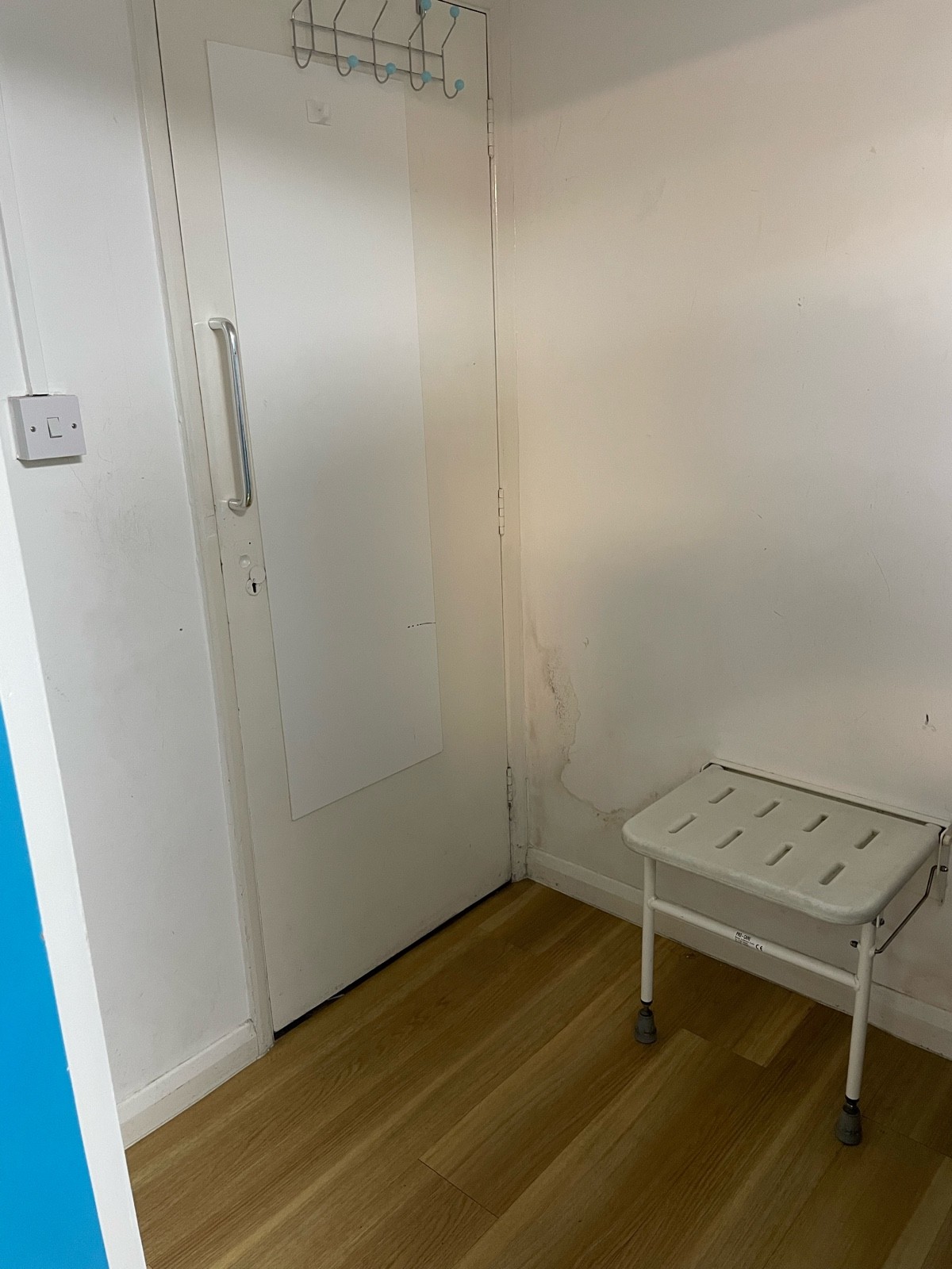 This is the inside of the fitting room, there is a seat on the back right wall, but no rails or supports.