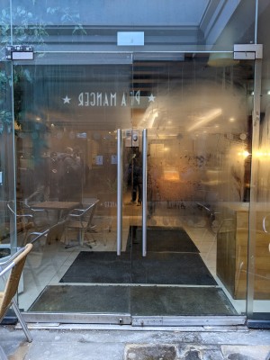 Glass doors with metal handles in centre. Pull or push to open.