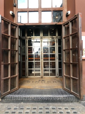 Glass doors with copper frame. Pull from metal handles in centre to open.