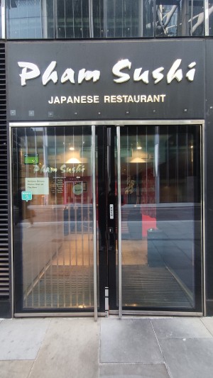 Glass doors with black frames ahead. Push metal handles in centre to open.