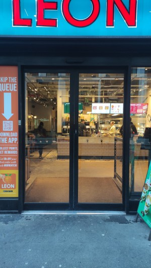 Automatic glass doors with black frames. Approach to open.