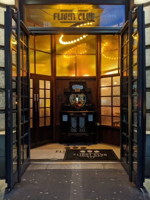 Glass and black wood doors with metal handles in centre. Pull to open.