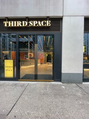 Black metal-framed glass doors. No handles. Push at centre to open.
