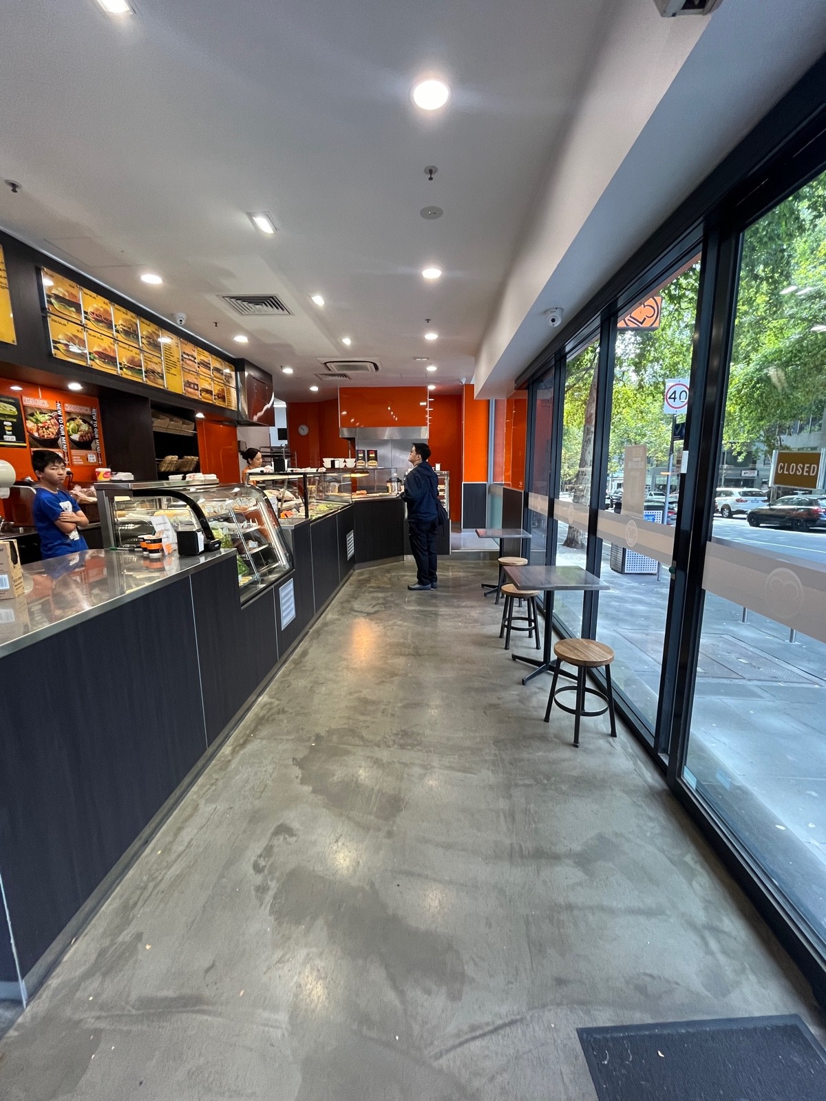 From entrance facing left. Service counter along left wall. Table with backless stools along right wall.
