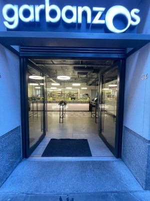 Glass doors with black frame ahead. Push silver metal handles in centre to open.