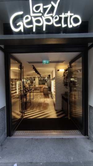 Glass doors with black frames. Push metal handles in centre to open.