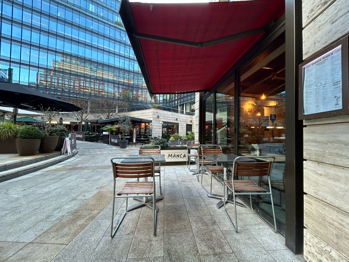 From entrance facing left. Tables and chairs ahead. Planter behind.