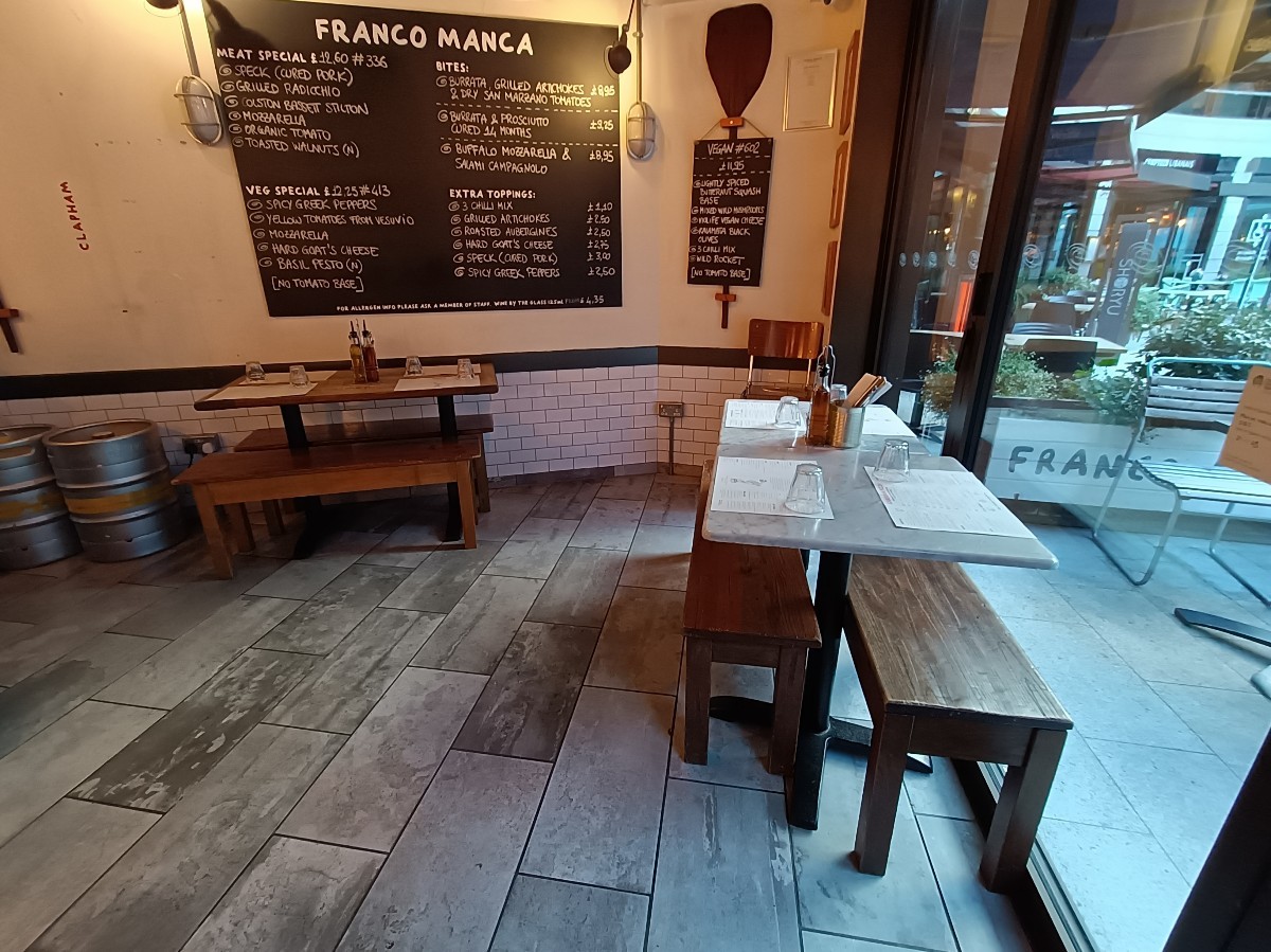 From entrance, looking right. Tables and benches along right and back left.