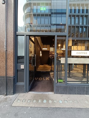 Glass door with black frame. Push silver, metal handle on right to open.