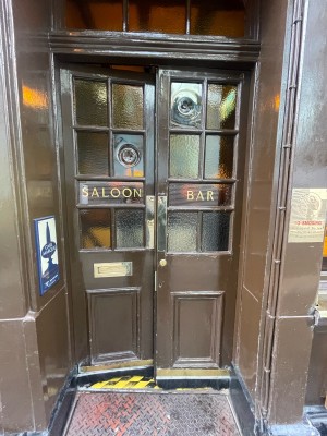 Brown wooden and glass doors ahead. Push from centre to open.