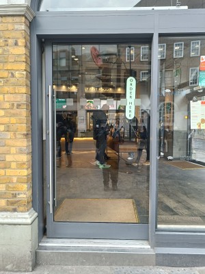 Glass door with grey frame. Silver metal handle on left, slide to right to open.