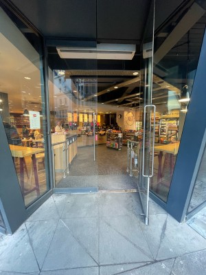 Glass doors ahead. Pull silver metal handles in centre to open.