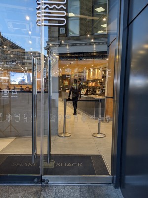 Glass doors with metal handles in centre. Pull to open.