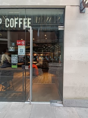 Glass door with silver, metal handle on left. Push to open.