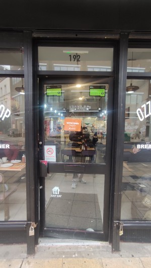Glass door with black frames ahead. Push on left to open.