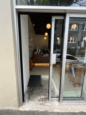 Glass door with silver metal frame. Door slides open to right from silver handle on left.