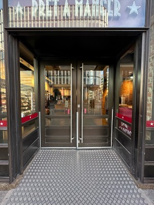 Glass doors with brown frame. Push handles in centre to open.