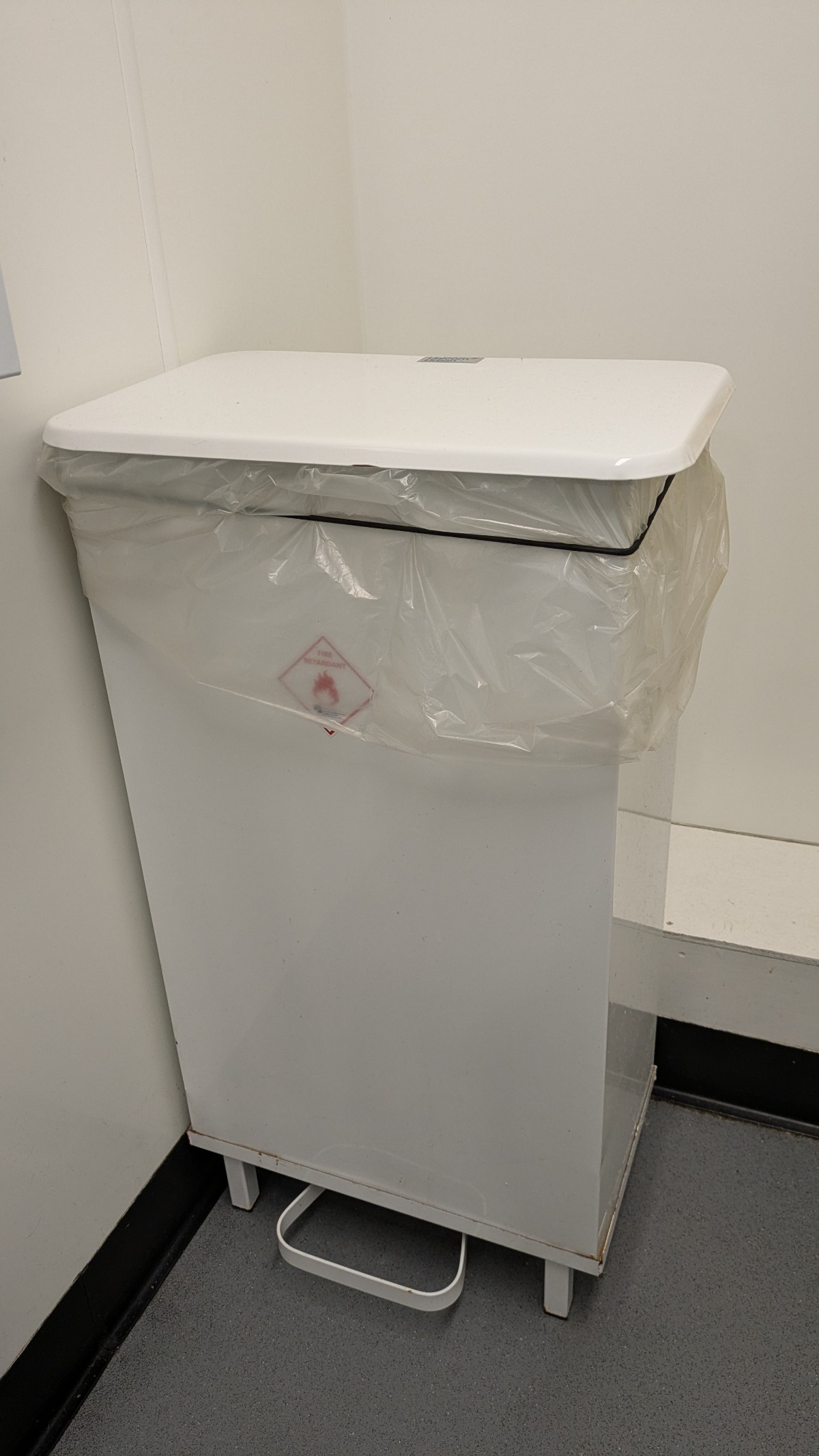 Foot pedal operated bin. Inaccessible for those with low muscle tone/ dexterity/ coordination/ wheelchair users. No other hygienic disposal options.
