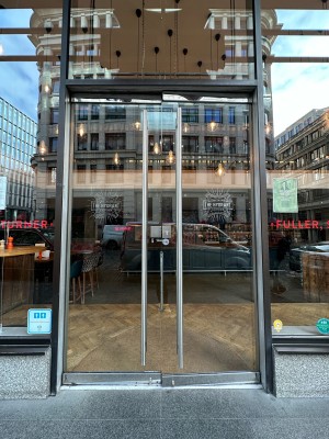 Glass doors with black frame. Push handles in centre to open.