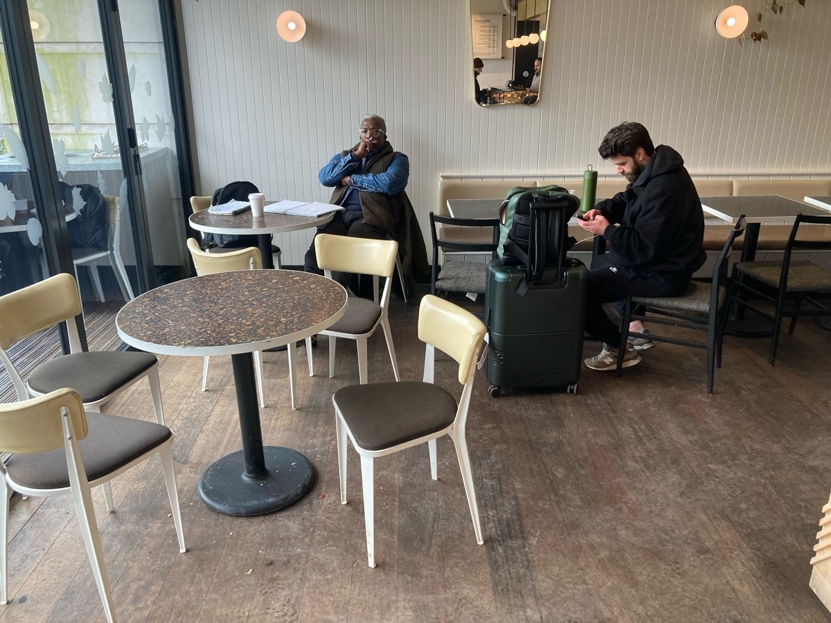 From entrance, facing left. Table and chairs along left. Half booth along back right.