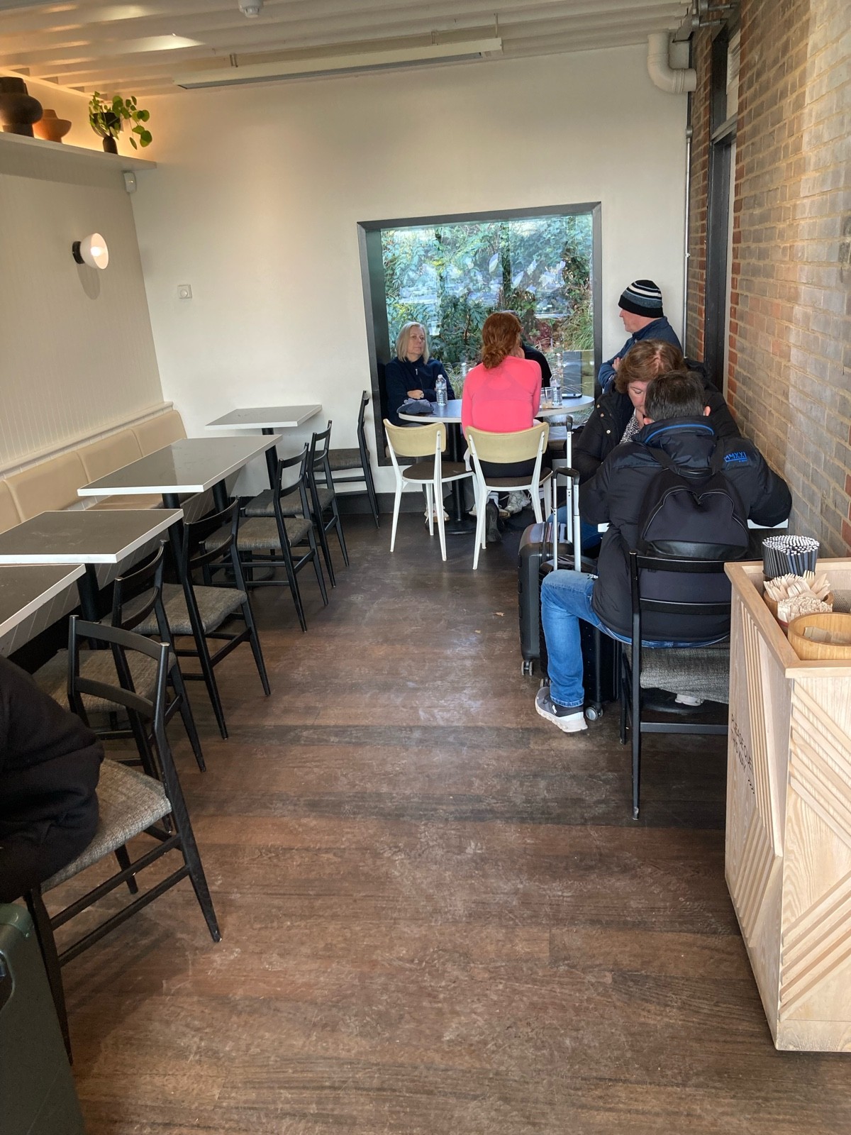 From bins, facing right. Half booth along left. Bin on right, tables and chairs behind and on back.