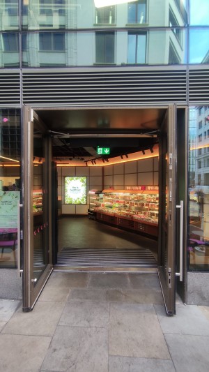 Glass doors with brown frames. Pull metal handles in centre to open.
