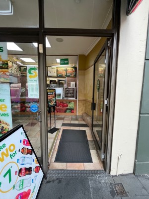 Glass door with brown metal frame. Push from left.