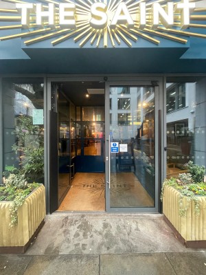 Glass doors with grey frame ahead. Push silver metal handles in centre to open.