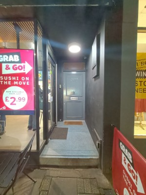 From street, facing venue. Step ahead. Doorway at back left.