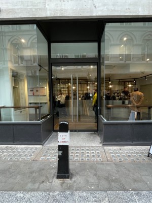 Metal-framed glass doors. Pull metal handles at centre to open.