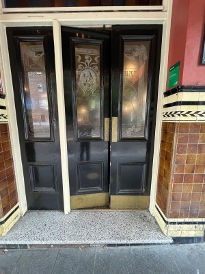 Glass double doors with black wooden frame. Push from middle.
