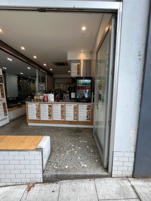 Glass door with silver metal frame. Push from left to open.