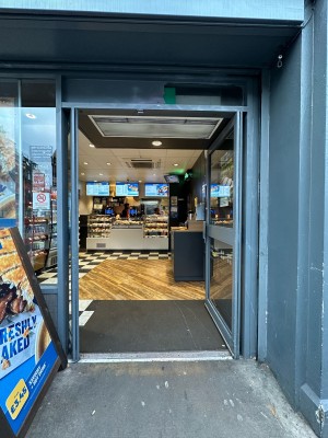 Glass door with grey frame. Push handles in centre to open.