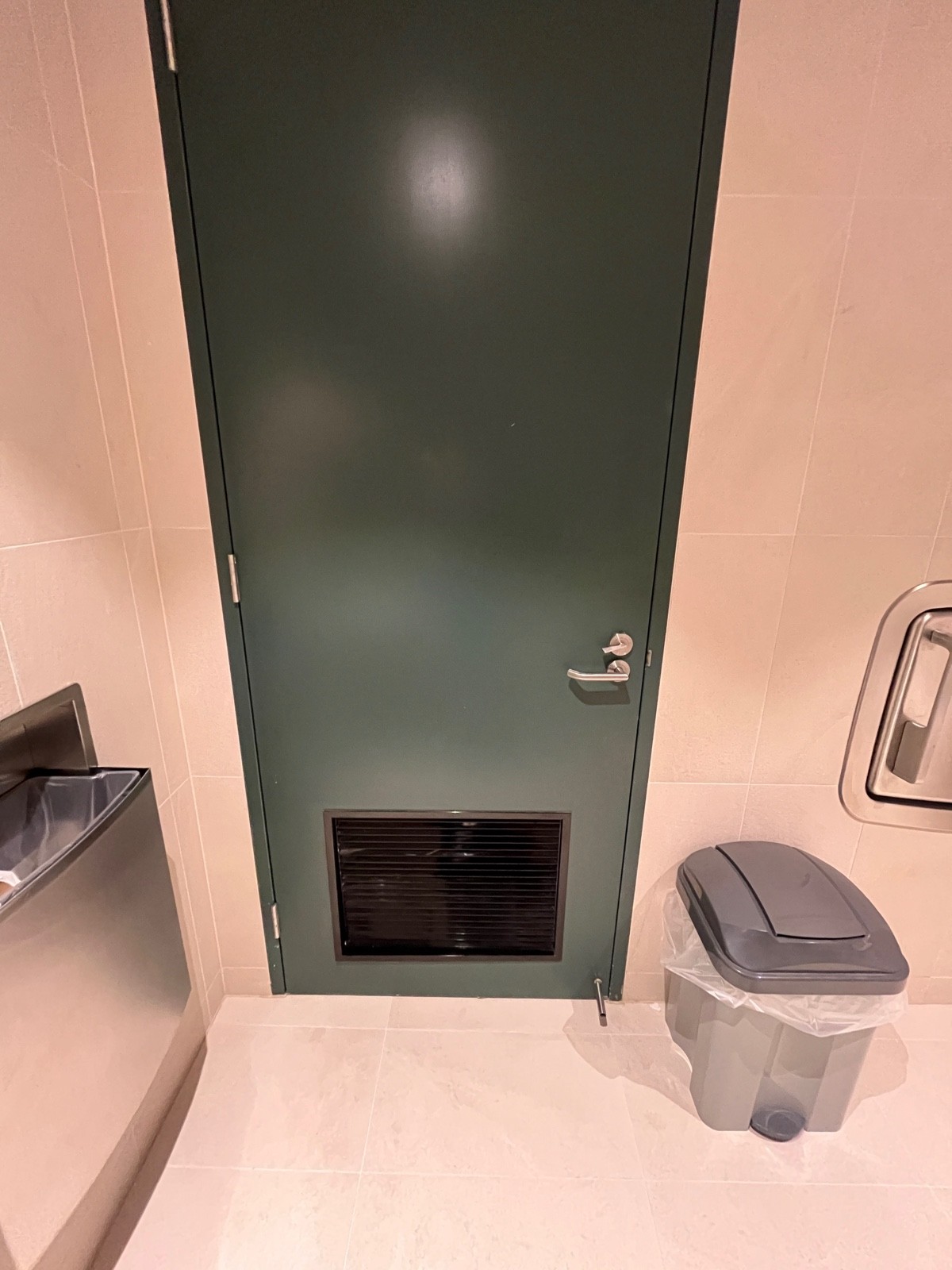 Back of door. Turn lock on right above silver handle. Turn handle and pull from right.