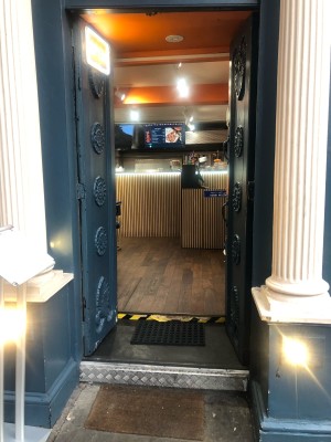Blue metal doors. Push metal handle on right to open.