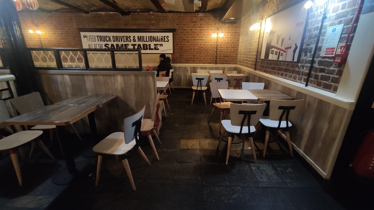 From entrance facing right. Tables and chairs along left and right.