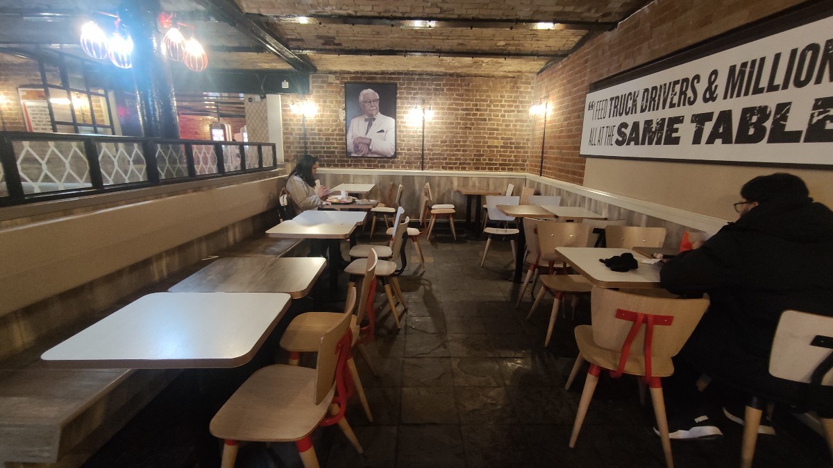 From end of table facing left. Half booths along left. Tables and chairs along right and back.