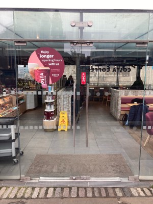 Glass doors with metal handrails in center. Push to open.