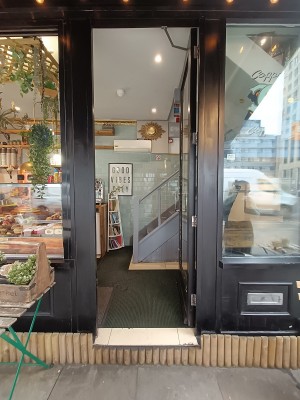 Glass door with black frame. Push silver handle on left to open.