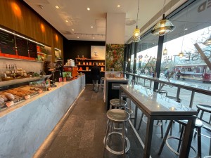 From entrance facing right. High table and stools along right and in center space. Counter to order along left.