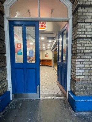 Blue glass and wooden doors ahead. Push from centre to open.