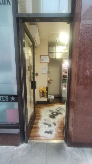 Glass door with black frames ahead. Push on right to open.