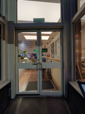 Glass doors with white frame. Pull silver handle in middle to open.